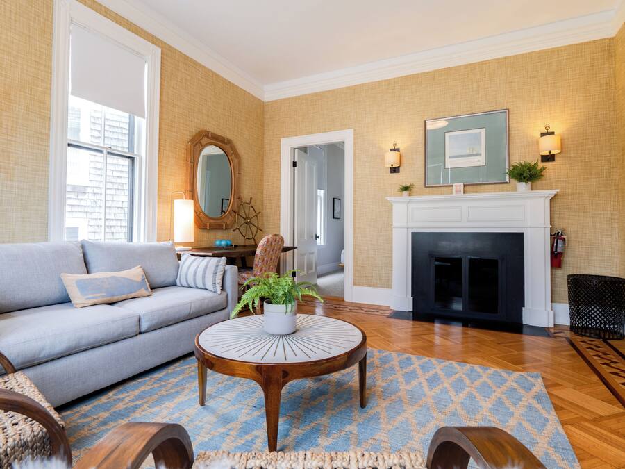 A living room with a sofa, round coffee table, and a fireplace.