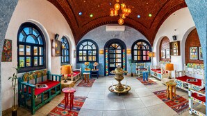 Een ruim interieur met gewelfde plafonds, kleurrijke zitplaatsen en een decoratieve fontein in het midden.