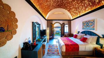 Habitación de hotel con cama, televisor, escritorio y vistas al exterior.