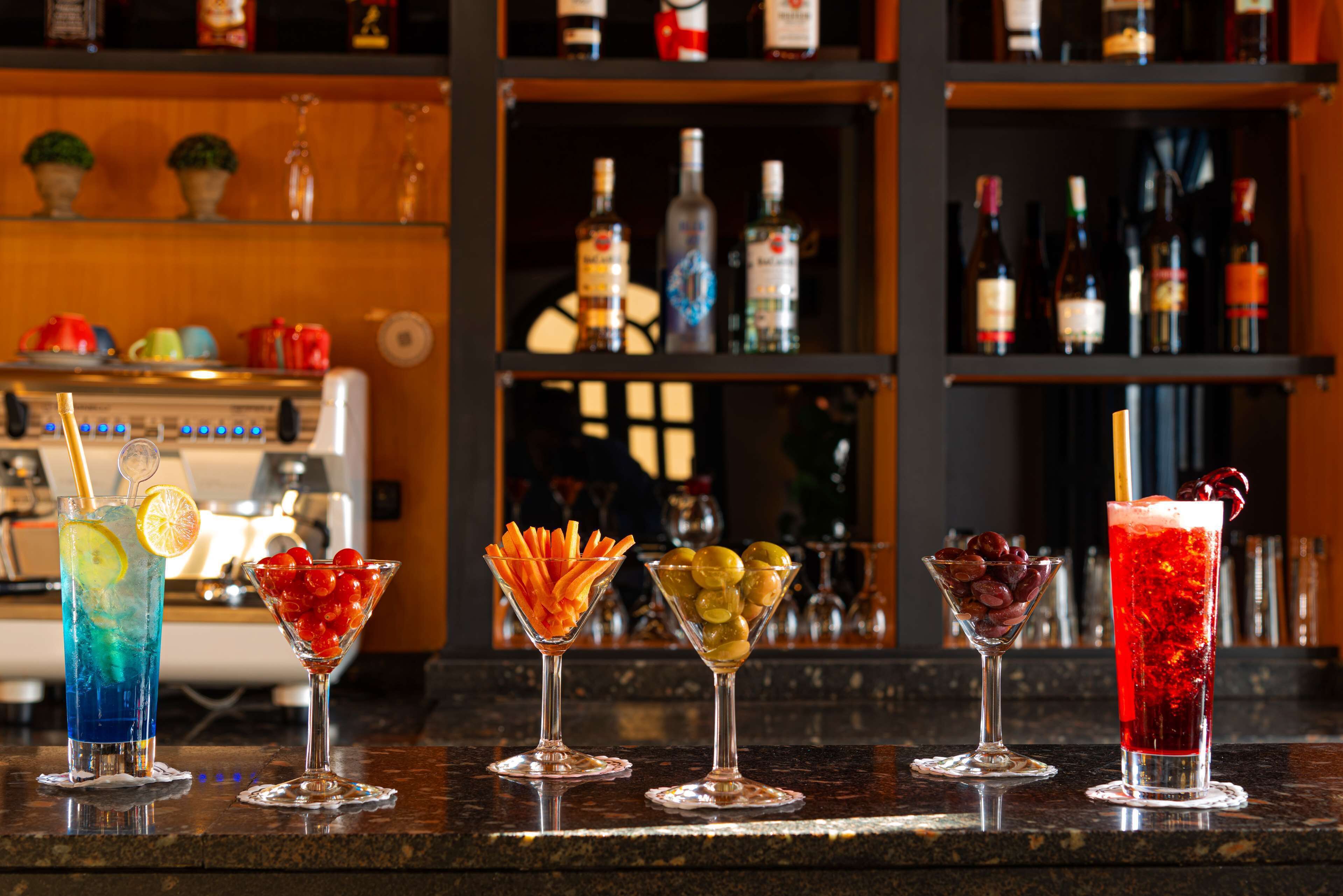 A bar counter with five different cocktails.