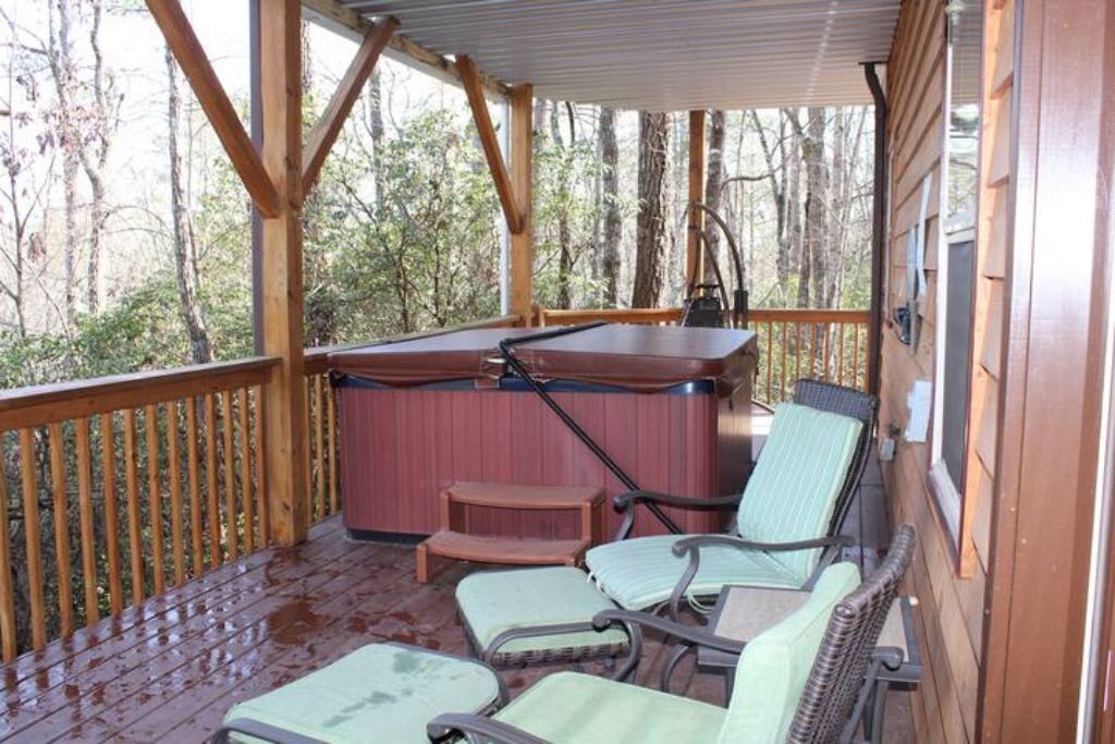 Una terraza techada al aire libre con barandas de madera, un jacuzzi y varias sillas.