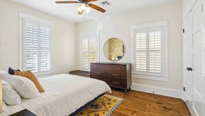 A bedroom with a bed, dresser, and ceiling fan. - Lux and Spacious for Groups near French Quarter (New Orleans)