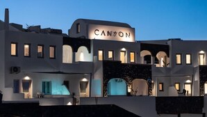A modern hotel with a prominent "CANYON" sign, featuring multiple balconies and a unique architectural design. - Canyon Santorini (Fira)