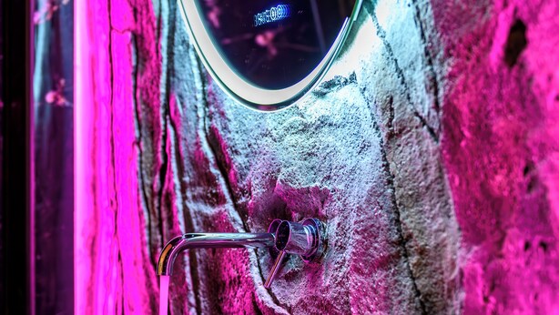 A bathroom with a stone sink, a mirror, and a faucet. - Canyon Santorini (Fira)