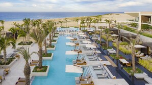 Et resort med swimmingpool, loungeområder og havudsigt.