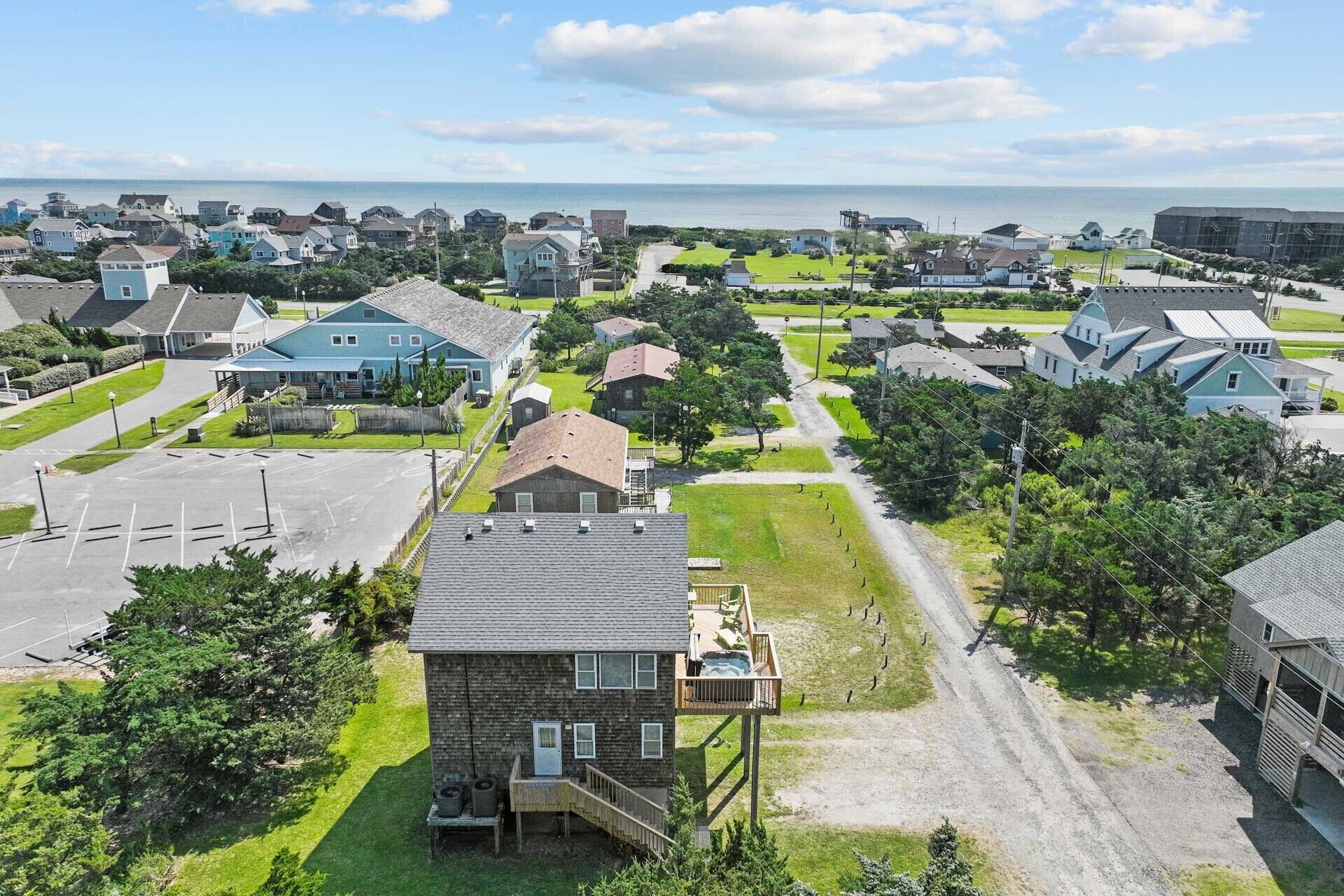 Un quartier résidentiel avec des maisons, un parking et une vue sur la mer.
