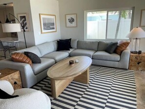 Relax in this stylish living room with a comfortable sofa, coffee table, and artwork on the walls.