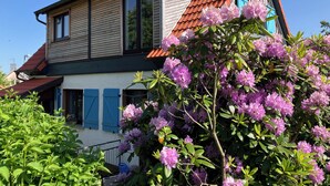 Punatiilikattoinen, puusivuverhous ja siniset ikkunaluukut – näin kuvailisin tätä kaksikerroksista taloa.