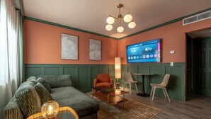 A living room with a sofa, armchair, coffee table, and TV mounted on the wall. - Condo On The Beach - Heated Pool - Self Check-in (Belleair Beach)