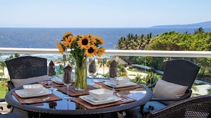 A round dining table with a clear view of the ocean and palm trees in the background. - Modern- Renovated- Breathtaking 6th Floor- 3 Bedrooms Villa Magna (Nuevo Vallarta)