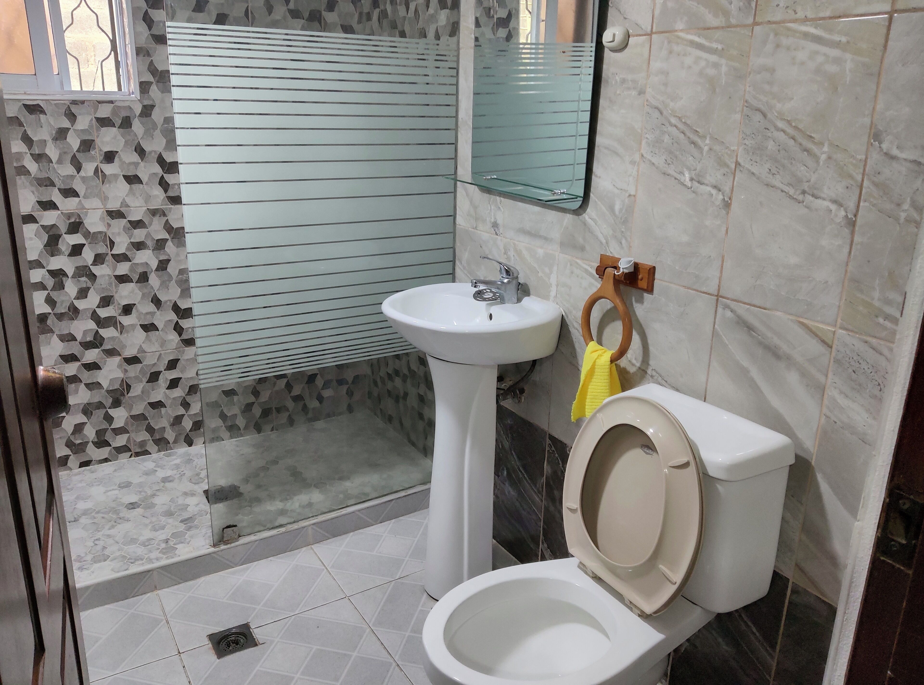 A bathroom with a toilet, sink, and shower.