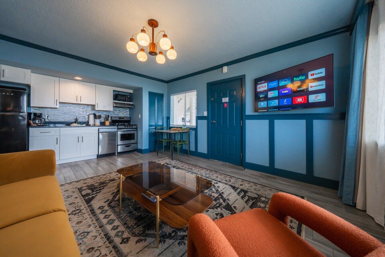 A compact living space with a kitchenette, a dining area, and a seating area with a coffee table.