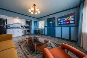 A compact living space with a kitchenette, a dining area, and a seating area with a coffee table.