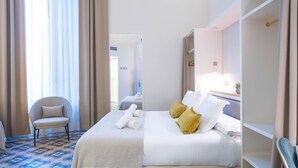A hotel room with a bed, a chair, a mirror, and a window with curtains. - Feelathome Casa Bertrand (Barcelona)