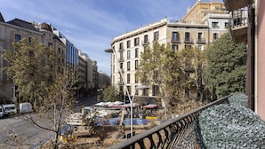 A street view with buildings, trees, and parked vehicles. - Feelathome Casa Bertrand (Barcelona)