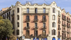 A multi-story building with balconies, a parking sign, and a clear blue sky. - Feelathome Casa Bertrand (Barcelona)
