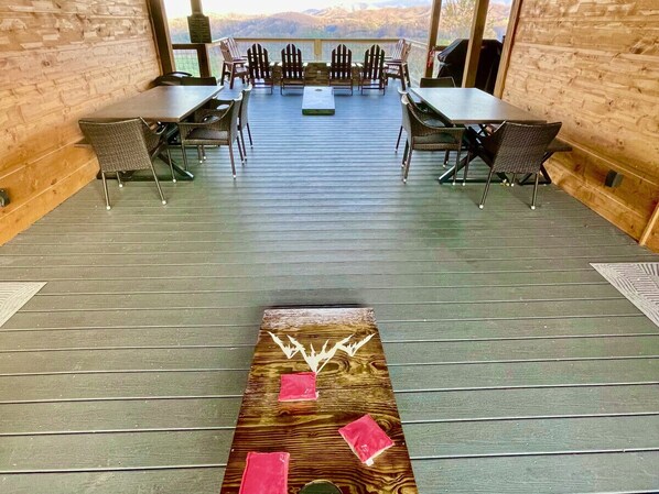 A wooden deck with outdoor seating and a view of the mountains.