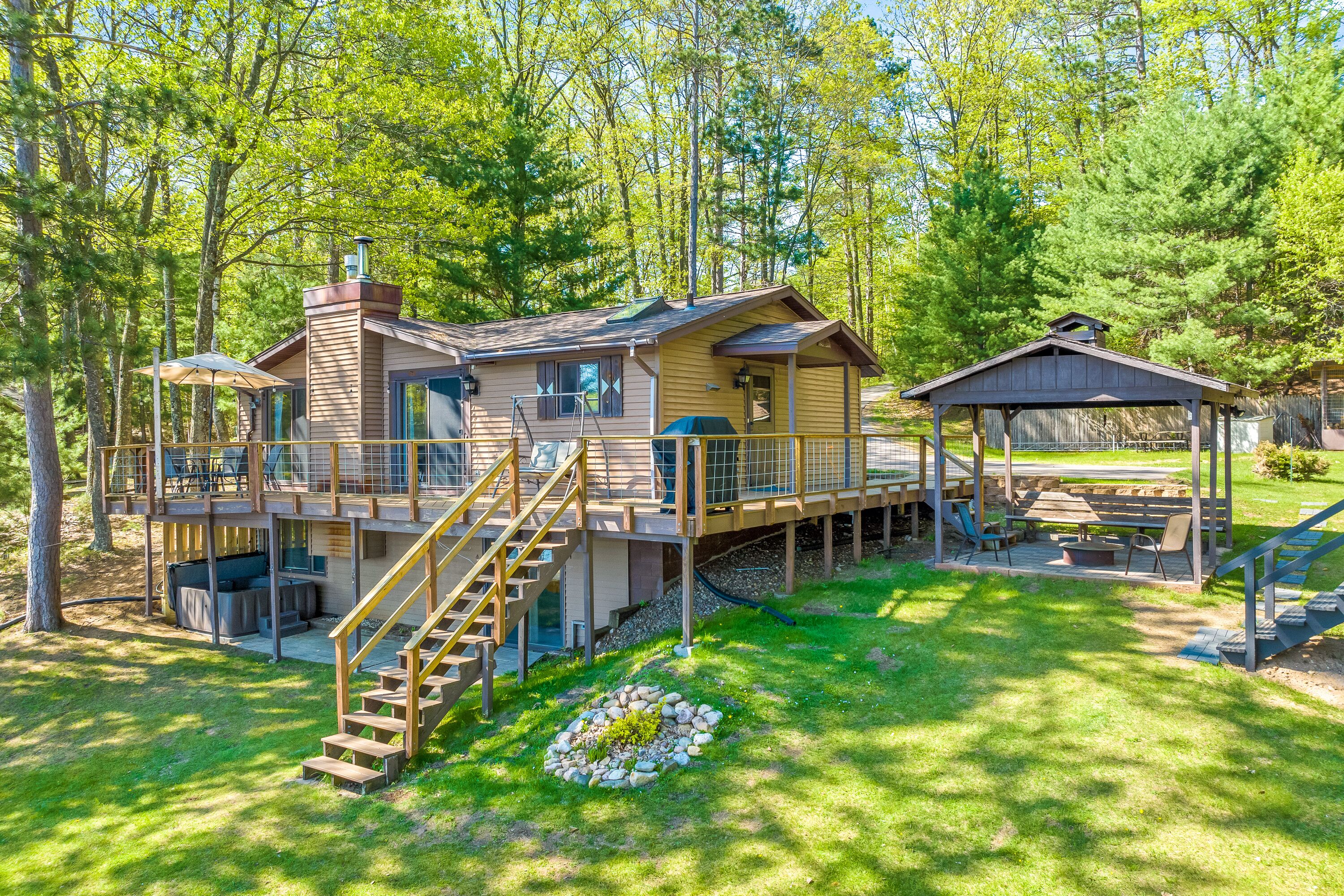 A cabin with a deck, outdoor seating, and a covered area.