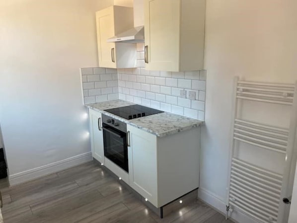 Kitchen features an oven, stovetop, and range hood.