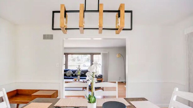 A dining area with a wooden table, white chairs, and a central potted plant. - Entire Home Quiet Neighborhood
6 bedrooms, 8 beds, 3 bathrooms  (Alexandria)