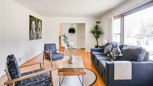 A modern living room with a sofa, armchairs, a coffee table, and artwork on the wall. - Entire Home Quiet Neighborhood
6 bedrooms, 8 beds, 3 bathrooms  (Alexandria)
