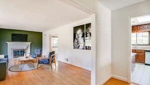 A spacious living room with hardwood flooring, a fireplace, and a dining area with blue patterned chairs. - Entire Home Quiet Neighborhood
6 bedrooms, 8 beds, 3 bathrooms  (Alexandria)
