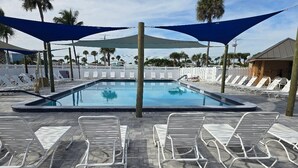 Une piscine avec des chaises longues et des parasols.