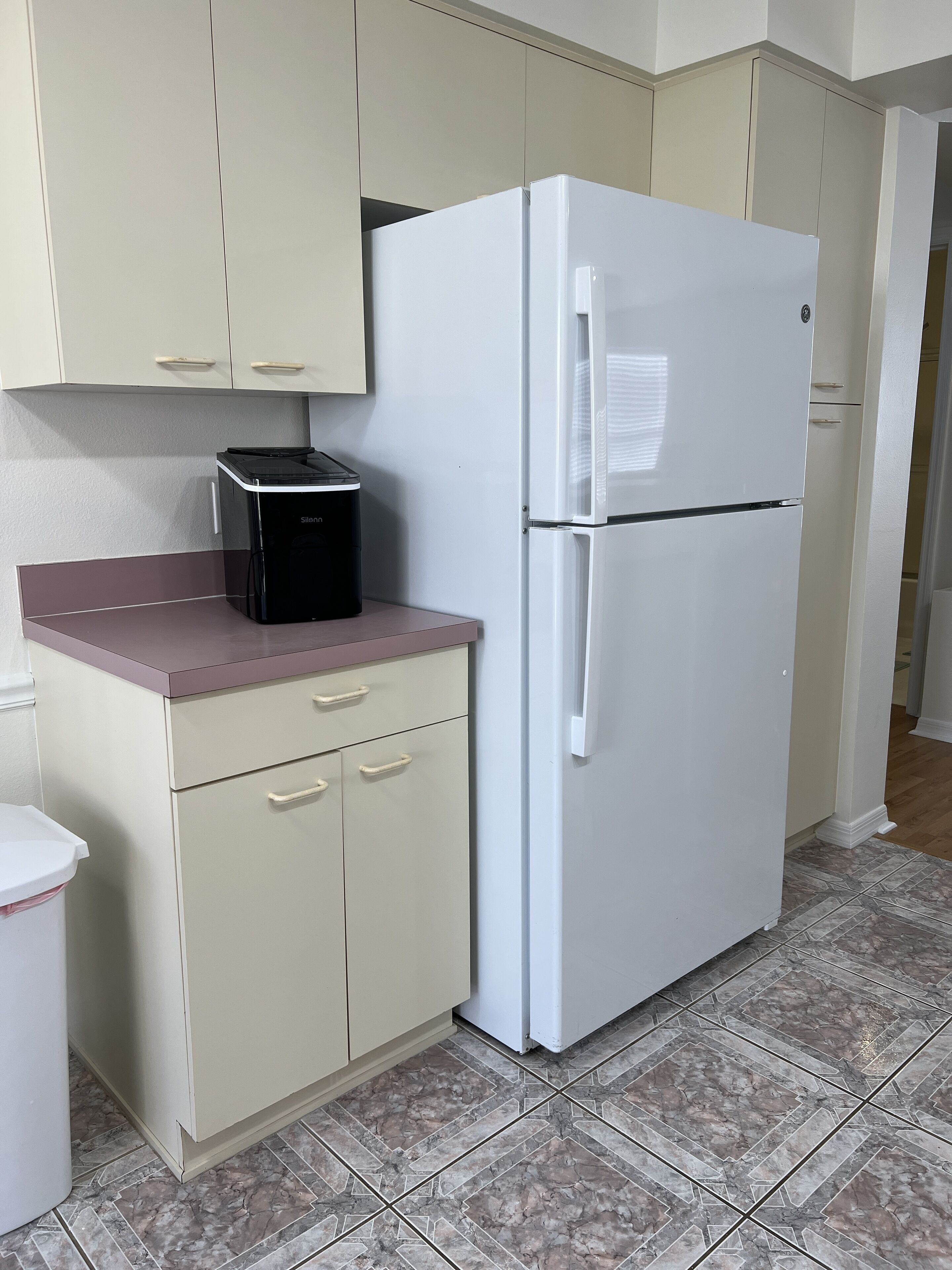 A kitchen with a white refrigerator, a microwave, and a sink.