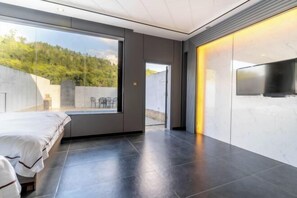 A modern bedroom with a large window, a bed, a flat-screen TV, and a marble wall. - Retang Village Longfa Hot Spring Villa (Huidong)
