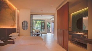 A hotel room with a large bed, a desk, a chair, a dining table, and a view of the outdoors. - Retang Village Longfa Hot Spring Villa (Huidong)