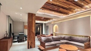 A modern living room with a sectional sofa, wooden coffee table, and a dining area in the background. - Retang Village Longfa Hot Spring Villa (Huidong)