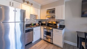 A compact kitchen with a stainless steel refrigerator, a built-in oven, and a microwave. - Condo On The Beach - Ocean Side View Balcony (Belleair Beach)