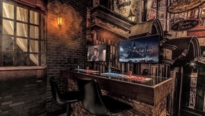 Zona de bar con pared de ladrillo, dos taburetes negros, una pantalla de televisión y un cartel que dice 'Potages'.