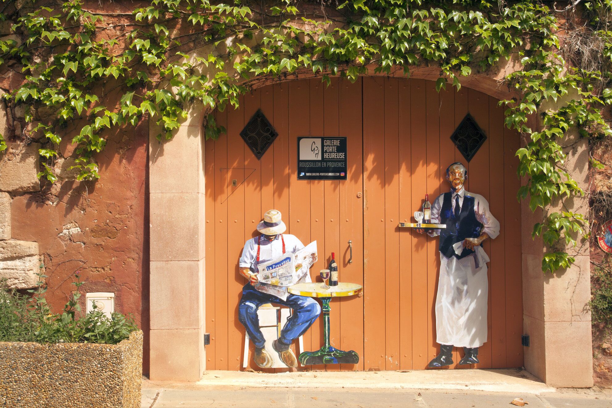 A rustic building with a wooden door and a sign indicating a gallery.