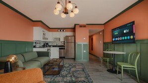 Una sala de estar moderna con sofá, mesa de centro y televisor mostrando servicios de streaming.