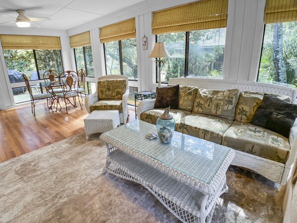 Un salón amplio con un sofá, una mesa de centro y una zona de comedor con sillas y una mesa.