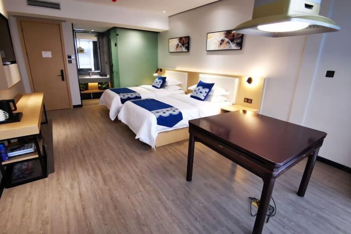 Una habitación de hotel con cama, mesitas de noche, escritorio y armario.