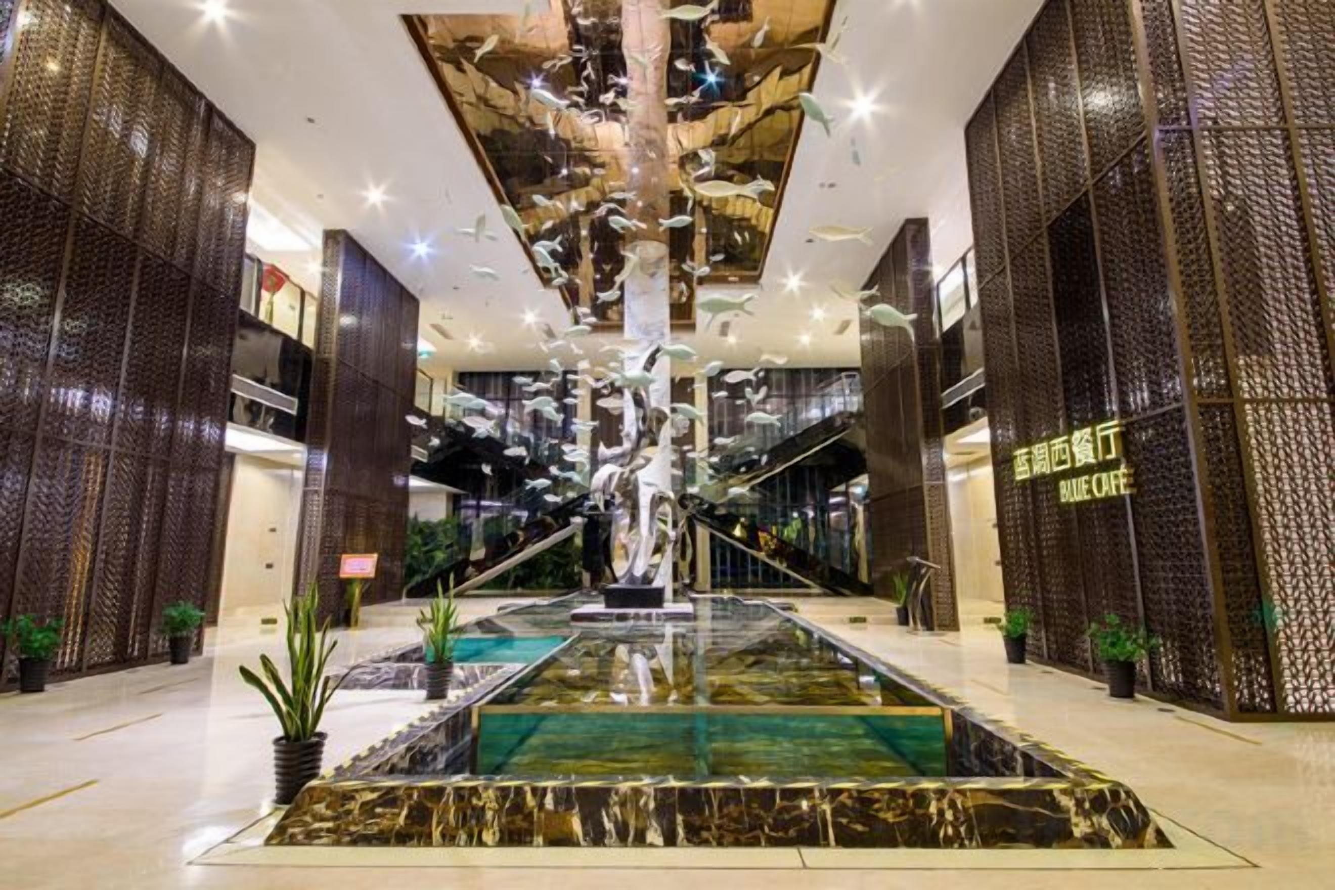 A spacious lobby with a central water feature, a staircase, and a modern design.