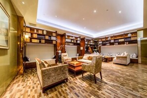 A spacious living area with multiple seating options, a patterned floor, and built-in bookshelves. - Scholars Hotel (Tongzhou Bay Business Center Yacht Club) (Nantong)