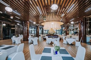 Un interior moderno con techo de madera, mesas redondas y sillas blancas.