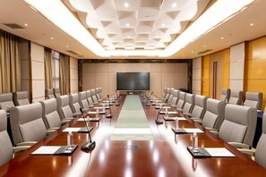A conference room with a long table, multiple chairs, a projector screen, and a large window. - Scholars Hotel (Tongzhou Bay Business Center Yacht Club) (Nantong)