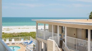 Ein Strandhotel mit Pool, Liegestühlen und Blick auf das Meer.