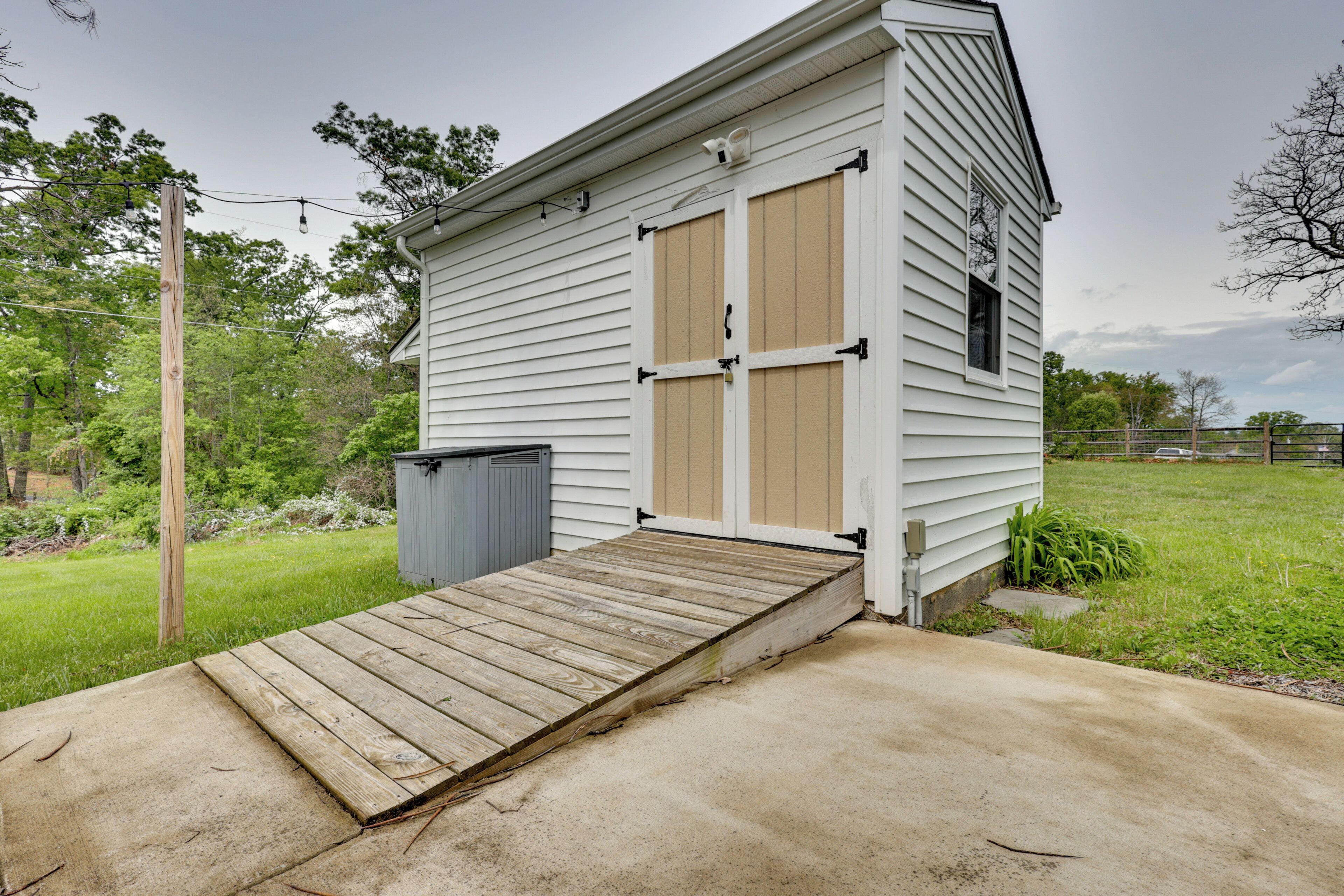 A small, single-story building with a wooden ramp leading to a garage.