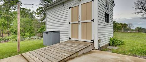A small, single-story building with a wooden ramp leading to a garage.