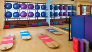 A gym with exercise equipment, including mats and balls.