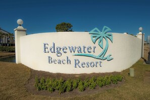 A sign for Edgewater Beach Resort with a palm tree logo.