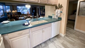 A modern kitchen with white cabinets, a blue countertop, and a dishwasher. - Best Ocean View-Overlooks Splash Pad-1st Floor-Edgewater 1-110! Beachfront Master-2 BD/2BTH! (Panama City Beach)