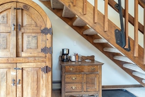 A wooden staircase with a handrail, a wooden cabinet with drawers, and a coffee maker on the cabinet. - Manitou Lodge 5 Hotel Room by Alpine Lodging Telluride (Telluride)