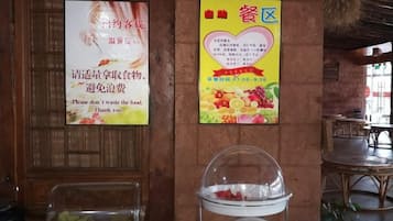 Interior de un restaurante con paredes de madera, un cartel con una imagen de frutas y una vitrina de vidrio con frutas.