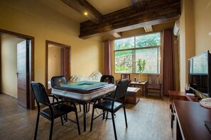 A dining area with a table, chairs, and a television. - Dating Inn (Pu'er)